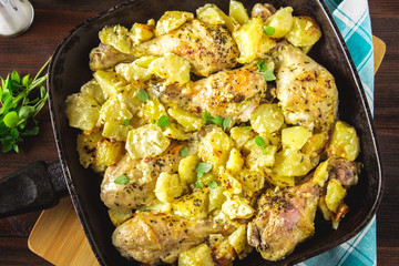 Roasted chicken leg with potatoes with caraway and garlic.