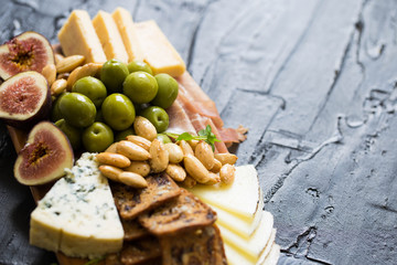 Beautiful Date Night Cheese Board with Cheddar Manchego and Blue Cheese Prosciutto Almonds and Olives on Wooden