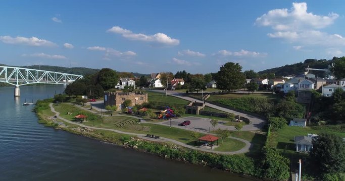 A dramatic reverse rising aerial establishing shot of the small western Pennsylvania town of Monaca on the Ohio River.  	