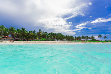 beautiful amazing tropical palm beach and tranquil turquoise ocean against blue sky background at Cuban Cayo Coco island