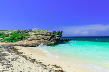 Fototapeta premium amazing inviting view on a cliff sitting in tranquil turquoise ocean and beach against blue sky magic background at Cayo Coco Cuban island on sunny summer day