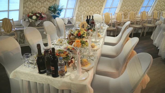 Beautiful luxury hall decoration for wedding celebrations at the restaurant. Delicious food and bottles with beverages on the tables