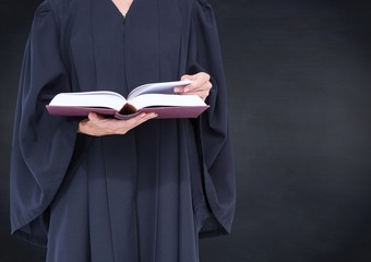 Female judge mid section with open book against navy chalkboard