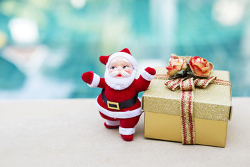 Santa claus with gold gift box over blurred colorful background, Christmas concept