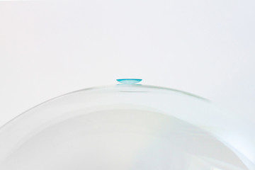 A blue lens on a glass surface.
