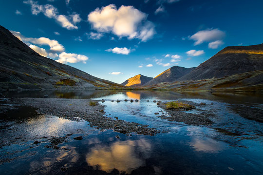 Russia. Murmansk region. Mountains of the Khibiny. Apatity. The city of Kirovsk. Reflection of the sky and mountains in the water.