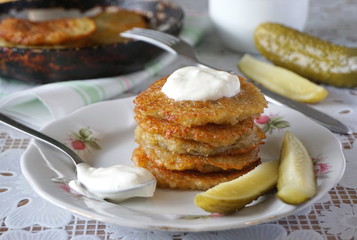Fried potato fritters with sour cream