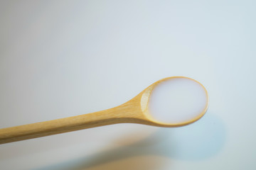 Sour cream in wooden spoon, milk in wooden spoon, yogurt in wooden spoon