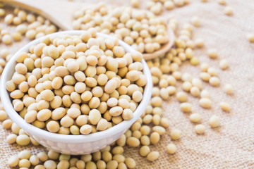 Closeup soy beans on white bowl with sackcloth background , healthy food concept