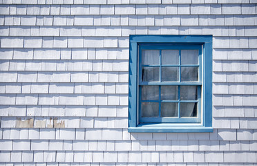 Fototapeta premium blue window frame on a white wooden wall background outside. part of the wall of the house with a window. Siding of the house from the wooden plank. Copy space for your text