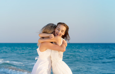 Fototapeta na wymiar Two women in a white dress on beach
