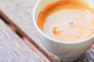 coffee espresso in white cup close up on wood background