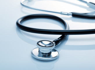 Stethoscope with reflection on glossy background.