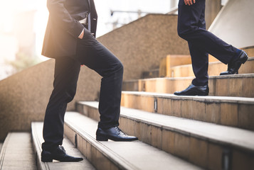 Close up legs of businessman walking stepping up stair in modern city, business growth, go up,...