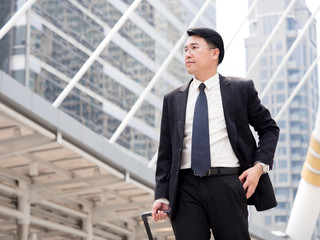 Fototapeta premium Portrait middle aged asian businessman in the city, businessman, manager, boss handsome looking with glasses holding bag in the city concept.