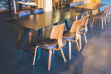 Table and wooden chairs in a modern coffee shop.