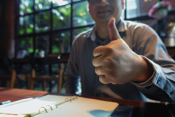 Young businessman showing thumbs up. closeup hand