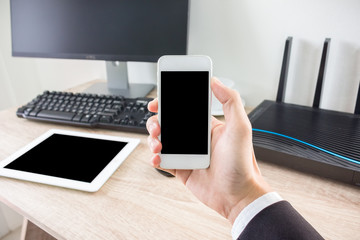 Man using smartphone ,computer pc and tablet on the background