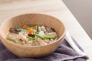 Asian congee with pork in white bowl.