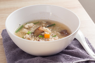 Asian congee with pork in white bowl.