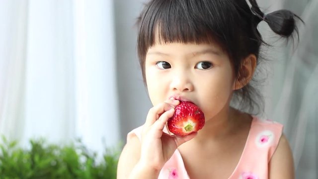 child eating strawberry.