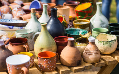 Naklejka na ściany i meble Ukrainian pottery. Pottery museum in Ukrainian village Oposhnya, center of Ukrainian pottery production. Different pottery products: bowls, pitchers, plates in museum.