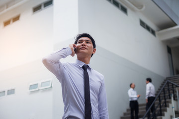 Portrait of a handsome young businessman who is negotiating a business on a mobile phone and negotiating a deal.