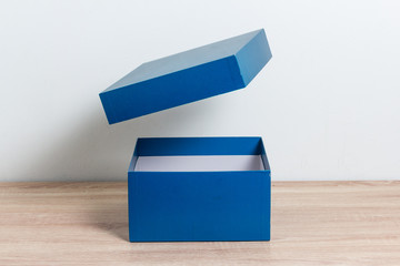 Blue open gift box on wooden table background