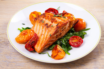 Salmon fillet with spinach, tomatoes and herbs, horizontal