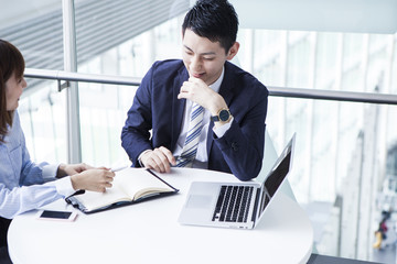 Business couple who spreads laptop computer and makes meetings
