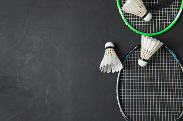 Shuttlecocks and badminton racket on black background. - obrazy, fototapety, plakaty