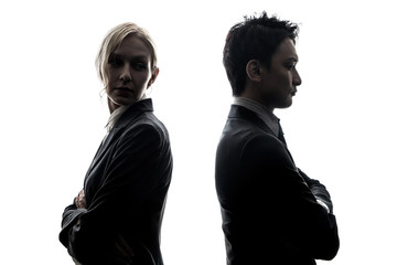 Silhouette of man and woman standing back to back.