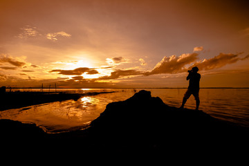 Obraz premium silhouette photographer shooting sunset