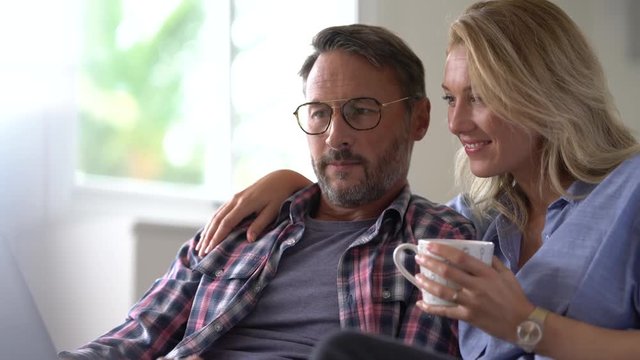 Mature couple connected on internet with laptop