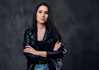 A fashionable brunette female dressed in a black leather jacket.