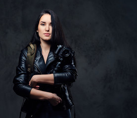 Brunette female photographer holds professional camera on a tripod.