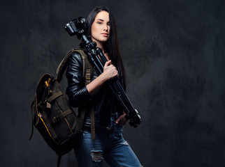 Fototapeta na wymiar Brunette female photographer holds professional camera on a tripod.