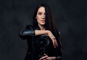 Brunette female photographer holds professional camera on a tripod.