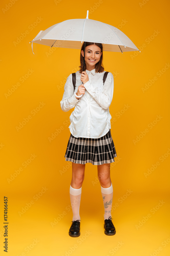 Wall mural Full length portrait of a smiling young schoolgirl in uniform