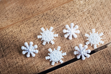 Fototapeta na wymiar Beautiful white plastic snowflakes close-up on a wooden background.