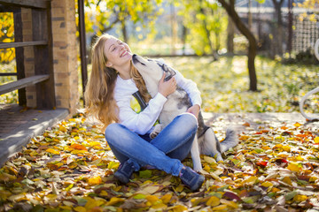 Happy girl in hugging husky dog in the autumn park © Евгения Ковальчук