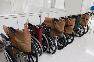 Rows of hospital wheelchair prepare for patient or disabled parked in empty room at hospital.