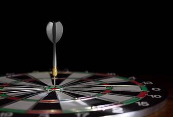 Dartboard with dart arrow hitting the center.