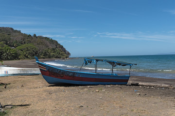 Fototapeta premium blue boat on the beach of the pacific ocean in Costa Rica