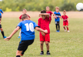 Fototapeta premium Kids soccer football - children players match on soccer field