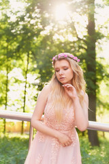 Naklejka premium Silhouette swirling in the setting sun in the beautiful woods of the bride in the peach dress with lace. Blonde with a good figure.The feeling of happiness and serenity