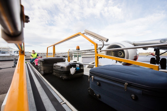 Baggage On Conveyor Belt Being Unloaded