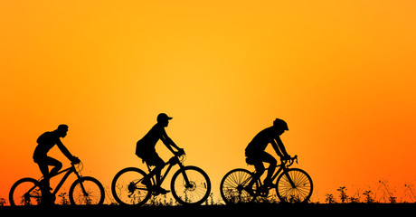 Obraz premium Silhouette man and bike relaxing on sunrise background