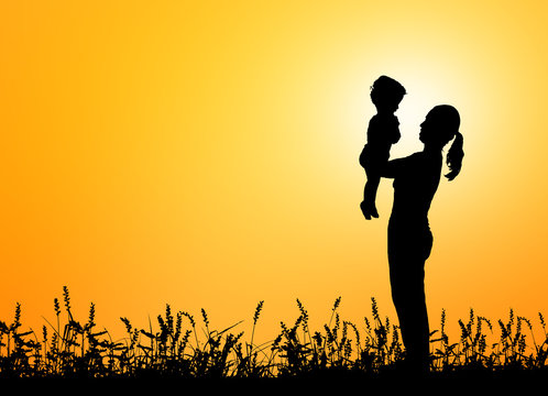 Silhouettes mother carries her son on sunset background