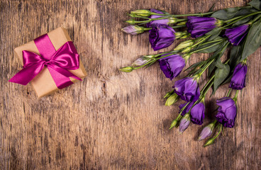 Gift box with bow and purple flowers. Eustoma. A romantic gift. Mothers Day.
